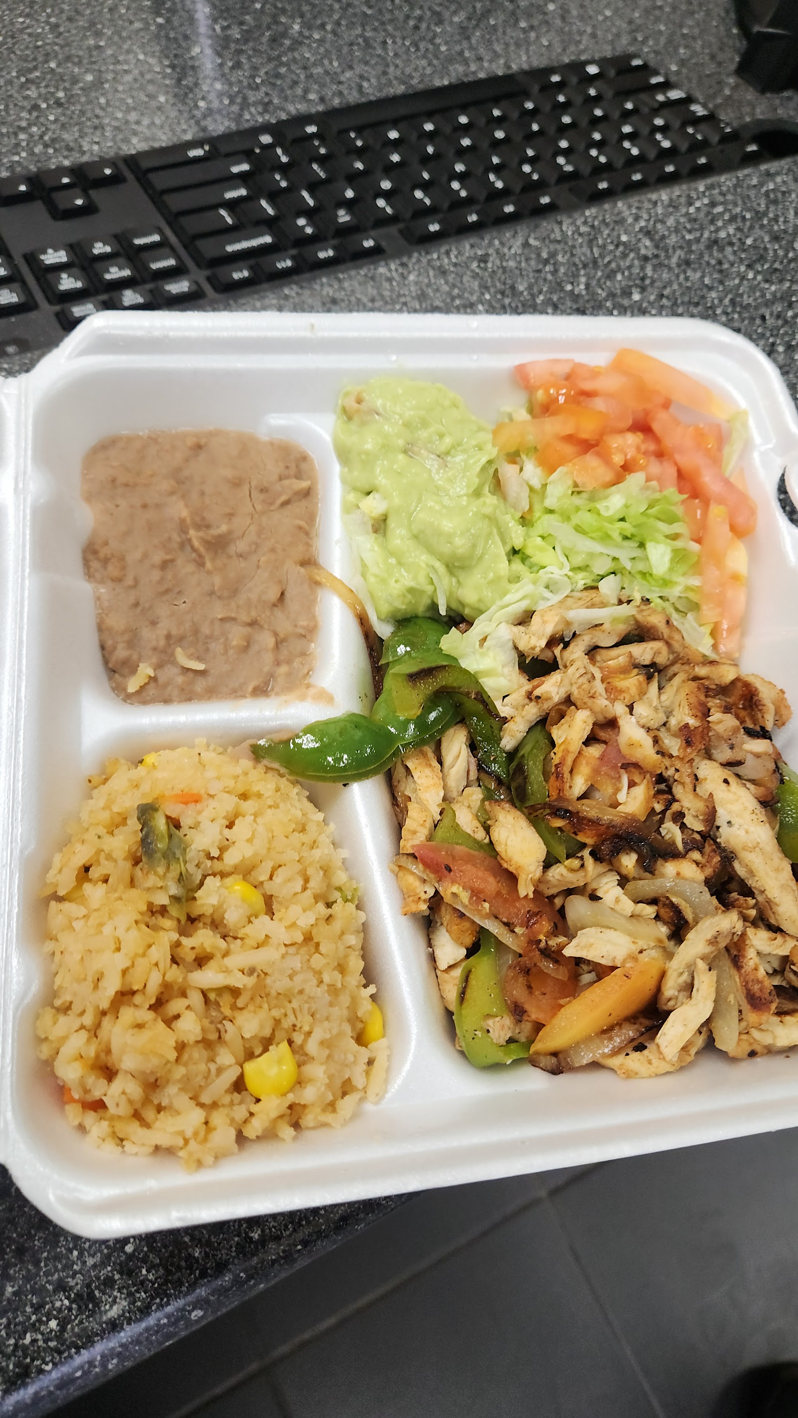 Chicken fajita plate with rice, beans, and guacamole