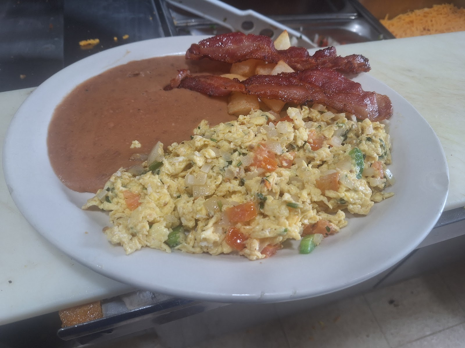 Bacon, home-fried potatoes, and eggs breakfast plate