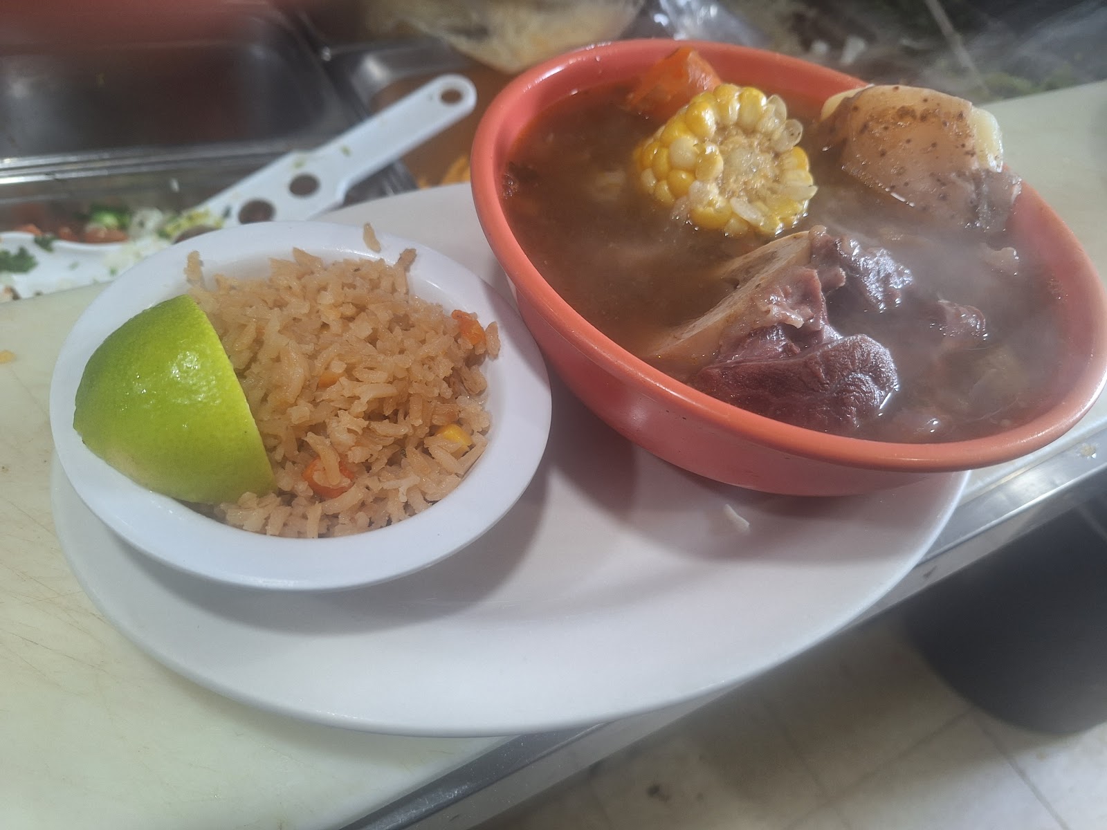 Bowl of traditional red menudo with corn and potato